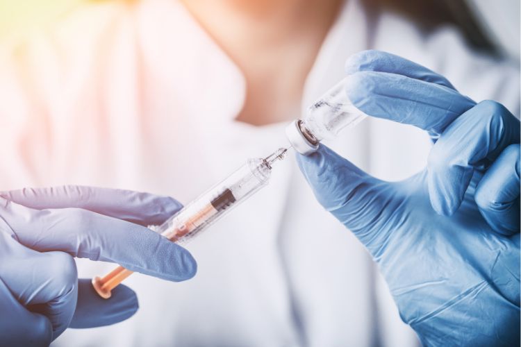 Rokote hoitajan kädessä.