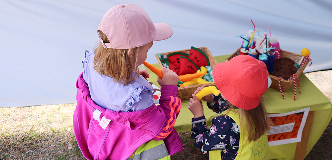 Lapset tutustuvat näyttelypöydän ruokatuotteisiin.