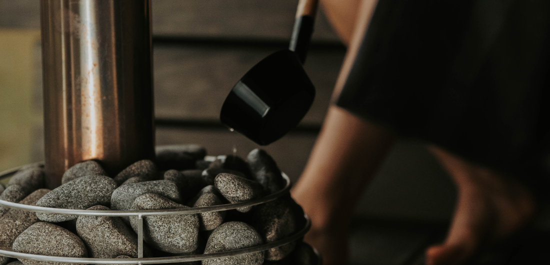 Löylykauha heittää vettä kiukaalle.