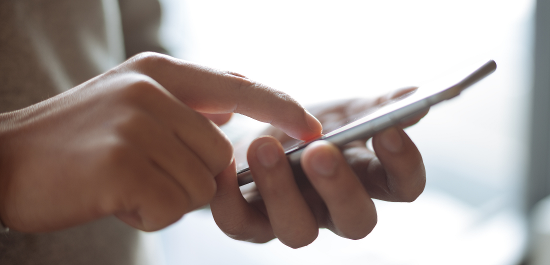 Puhelimen näyttöä näppäillään.