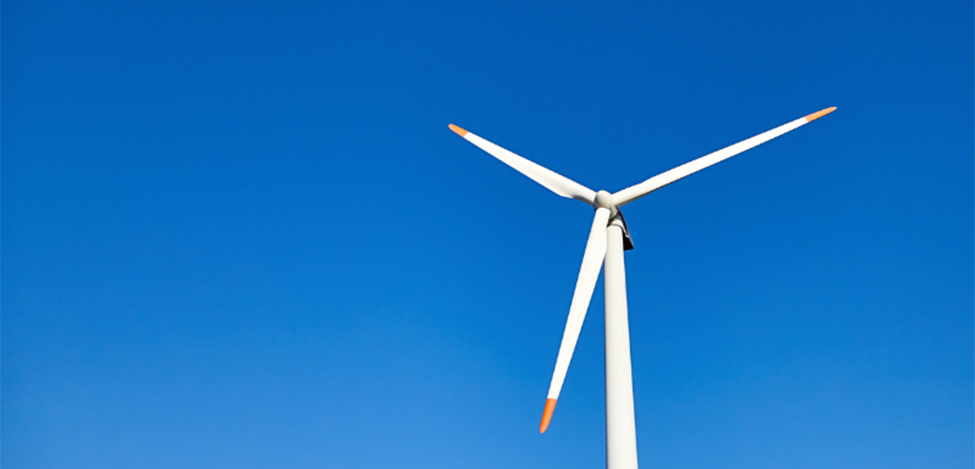 Tuulimyllyn yläosa sinistä taivasta vasten.