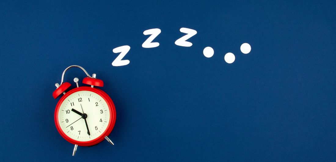 Punainen herätyskello sinisellä taustalla.