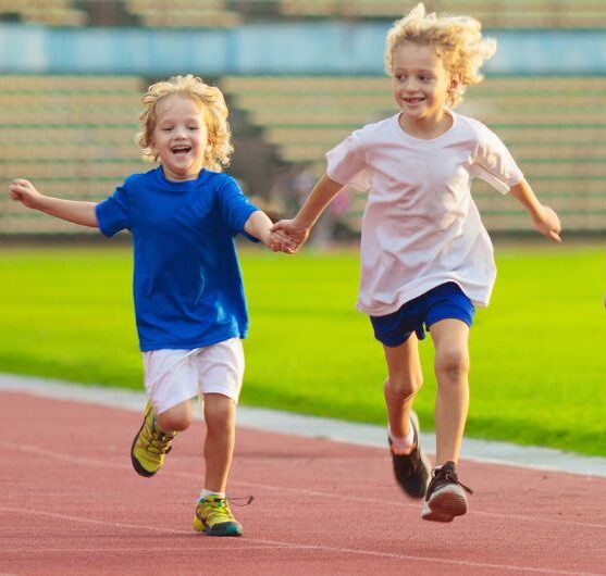 Lapset juoksevat urheilukentällä